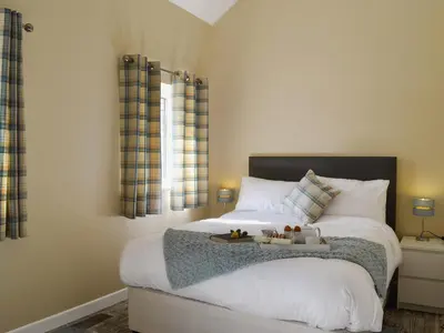 a bedroom with a bed with white sheets and pillows at Tawelfan in Cilcennin