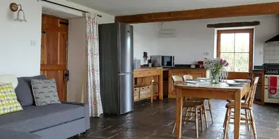 a kitchen with a table and a stainless steel refrigerator at Drovers Rest Farm Stay in Hay-on-Wye
