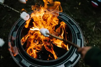 a person cooking marshmallows over a campfire at Drovers Rest Farm Stay in Hay-on-Wye