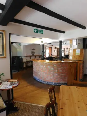 a room with a bar and a table and chairs at The Railway Inn in Forden