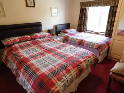 a hotel room with two beds and a window at The Railway Inn in Forden