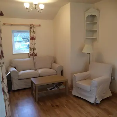 a living room with a couch and a chair at Ty'r Afon - River Cottage in Bala