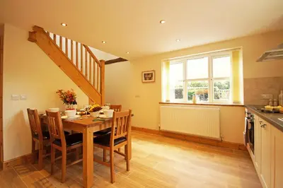 a kitchen with a table and chairs and a staircase at Hen Gapel in Aberhosan
