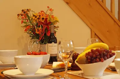 a table with a bottle of wine and bowls of fruit at Hen Gapel in Aberhosan