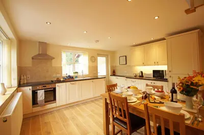 a large kitchen with a wooden table and chairs at Hen Gapel in Aberhosan