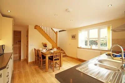 a kitchen and dining room with a table and a staircase at Hen Gapel in Aberhosan