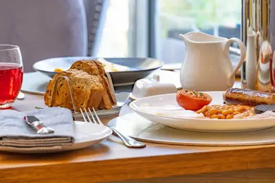 a table with a plate of food on a table at Awel y Mor in Aberdyfi