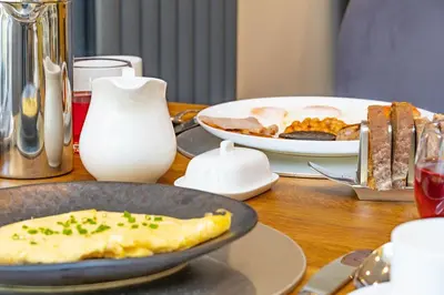a table with a plate of eggs and a plate of food at Awel y Mor in Aberdyfi