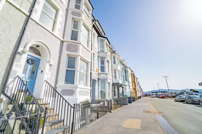 a row of buildings on a street with cars parked at Awel y Mor in Aberdyfi