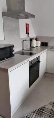 a kitchen with white cabinets and a stove top oven at Bodalwyn Guest House in Aberystwyth
