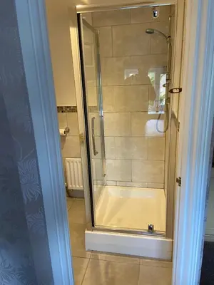 a shower with a glass door in a bathroom at Bodalwyn Guest House in Aberystwyth