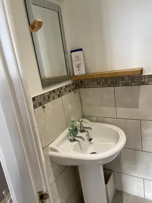 a bathroom with a white sink and a mirror at Bodalwyn Guest House in Aberystwyth