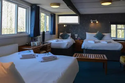 a hotel room with two beds and a table at Llanerch Inn in Llandrindod Wells