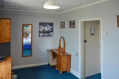 a room with a desk and a bed and a mirror at Llanerch Inn in Llandrindod Wells