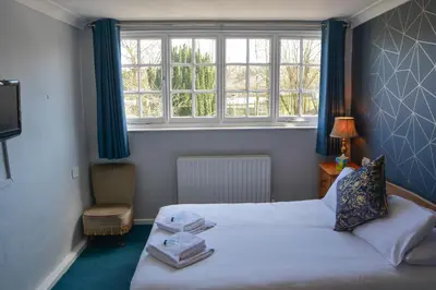 a small bedroom with a bed and a window at Llanerch Inn in Llandrindod Wells