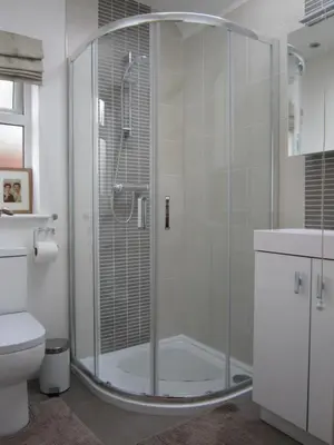 a shower with a glass door in a bathroom at Temeside Garden House in Ludlow