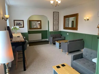 a waiting room with couches and a table and mirrors at Abbots Mead Hotel in Shrewsbury
