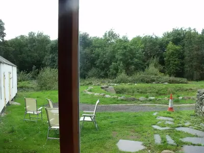a group of chairs sitting in the grass at Bryn Cottage in Llandderfel