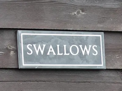 a sign on a wooden wall with the word yellows at Dee Valley Cottages in Llangollen