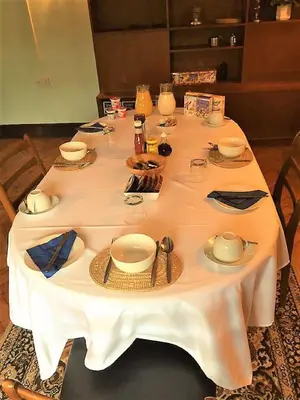 a table with a white table cloth and plates and bowls at Ty Newydd in Llangadog