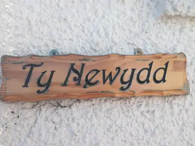 a sign that says tv reviewed sitting on a bed at Ty Newydd in Llangadog