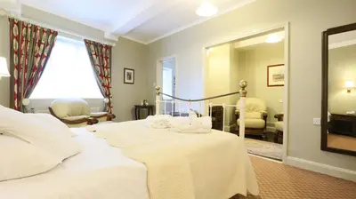 a bedroom with a large white bed with a mirror at The Lion Hotel Shrewsbury in Shrewsbury