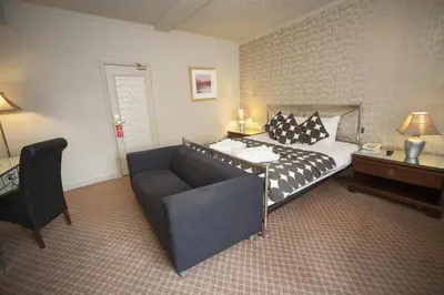 a hotel room with a bed and a couch at The Lion Hotel Shrewsbury in Shrewsbury
