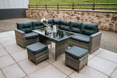 a patio with a table and chairs and a couch at Sunnyside farmstay & hottub near Brecon Beacons sleeps 8 in Lower Chapel