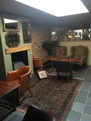 a waiting room with chairs and a fireplace at Plas Yn Dre in Bala