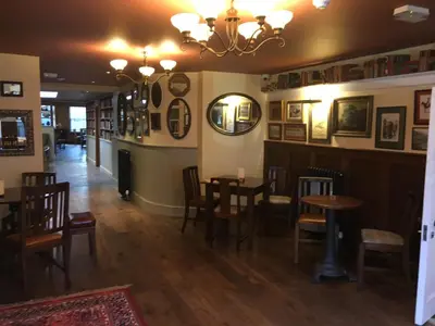 a dining room with tables and chairs and a chandelier at Plas Yn Dre in Bala