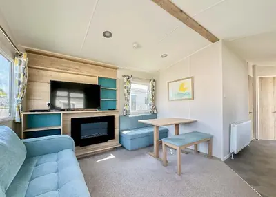 a living room with a blue couch and a table at Pencnwc Holiday Park in Llanllwchaiarn