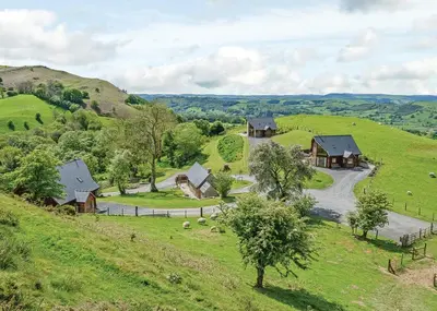 an aerial view of a farm with houses on a hill at Slate House Lodges in Towyn