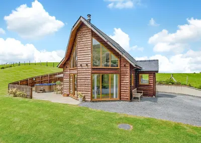 a wooden house with a large group of windows at Slate House Lodges in Towyn