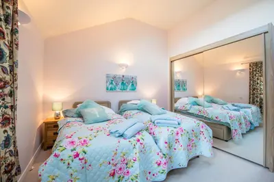 a bedroom with two beds and a large mirror at Y Grange in Llanfihangel-y-creuddyn
