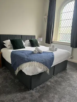 a bedroom with a large bed with a blue blanket at St Nicholas Boutique Hotel in Shrewsbury