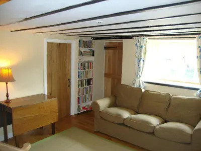a living room with a couch and a window at Ceiros Cottage in Llangammarch Wells
