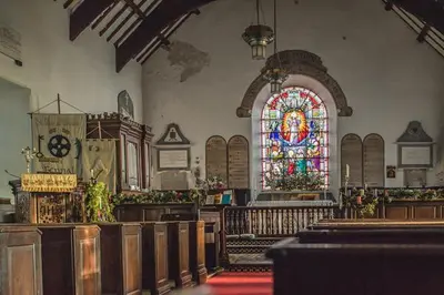 a church with a stained glass window and pews at Llety Brynawel Guest House in Pennal
