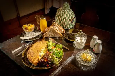 a table topped with plates of food and a salad and a sandwich at Taldraeth - Old Vicarage Guest House in Penrhyndeudreath