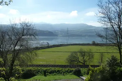 a view of a body of water with a bridge at Taldraeth - Old Vicarage Guest House in Penrhyndeudreath