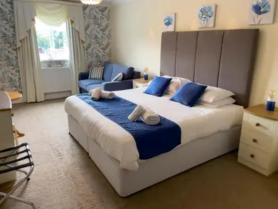 a bedroom with a large bed with blue pillows at Llanina Arms in Llanarth
