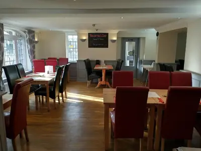 a dining room with tables and chairs in a restaurant at Llanina Arms in Llanarth