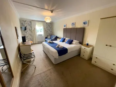 a bedroom with a large bed with blue pillows at Llanina Arms in Llanarth