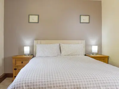 a bedroom with a bed with two lamps on night stands at Brynllin Holiday Cottages - Dildre in Penuwch