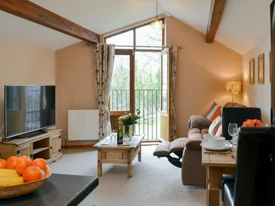 a living room with a couch and a tv at Y Bwthyn Pren in Aberaeron