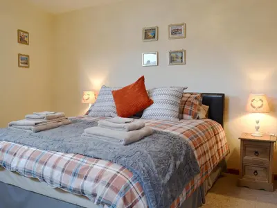 a bedroom with a bed with towels on it at Y Bwthyn Pren in Aberaeron