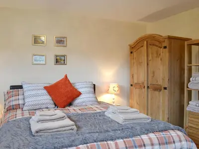 a bedroom with a bed with towels on it at Y Bwthyn Pren in Aberaeron