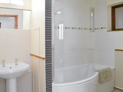 a bathroom with a sink and a tub and a toilet at Y Bwthyn Pren in Aberaeron