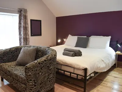 a bedroom with a large bed and a couch at The Loft - Uk6210 in Llanerch-Aeron