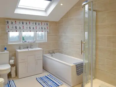 a bathroom with a tub and a toilet and a sink at Montrose in New Quay