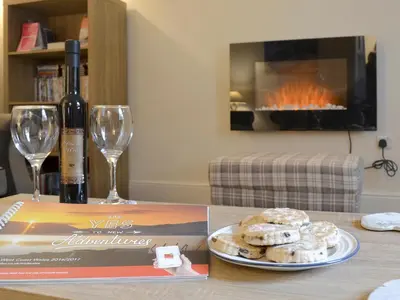 a table with a bottle of wine and a plate of donuts at Montrose in New Quay